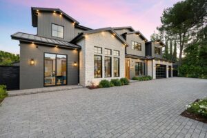 Modern house with large driveway at sunset.